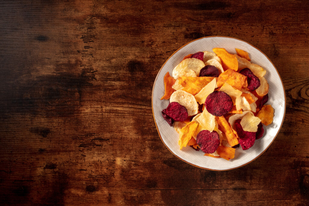 Gemüsechips, besser,gesünder,Teller,Diabetes,abnehmen, Kalorien, weniger, braune Tischplatte