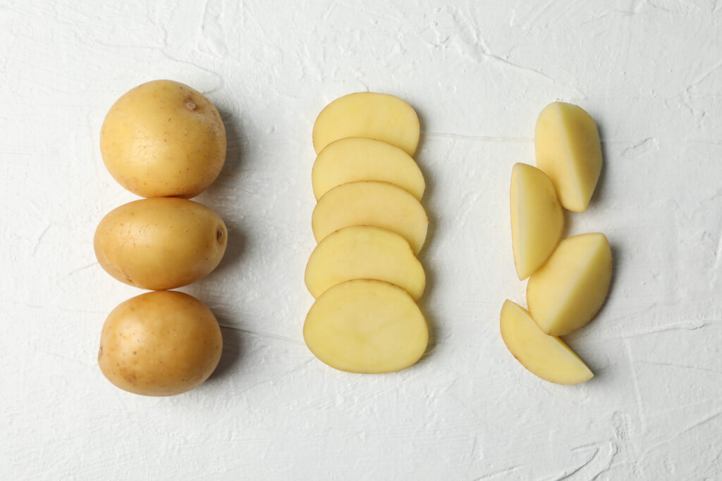 Kartoffeln, in Scheiben, in Ecken,gechnitten,grauer Hintergrund, selbermachen, Chips